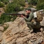 Un miliciano empuñando su arma en la Sierra
